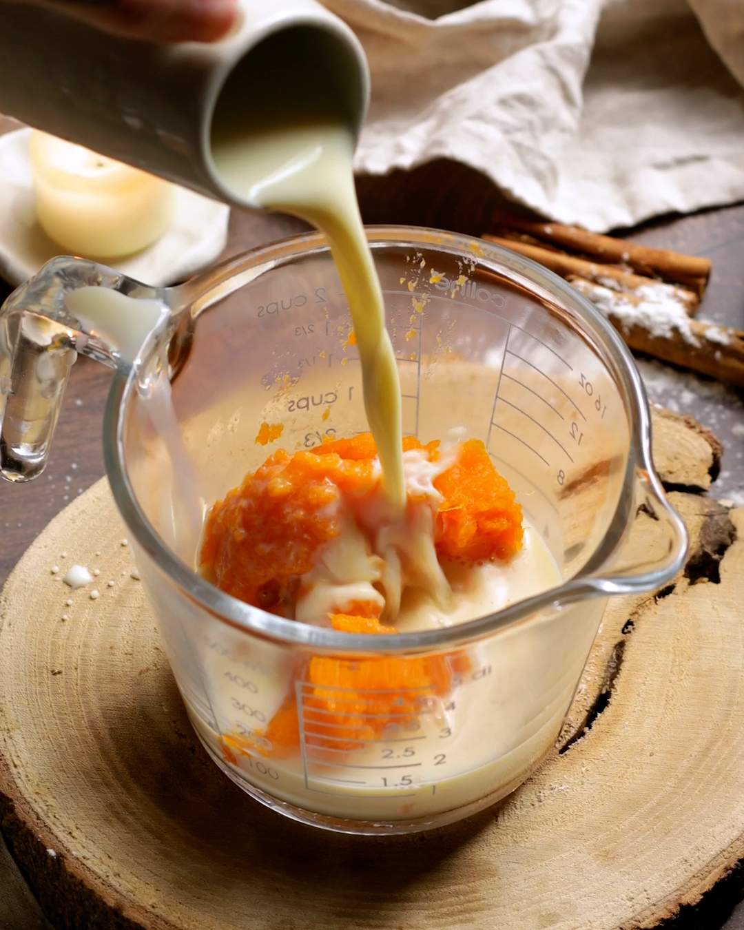 Pouring plant milk into a jug with mashed sweet potato.