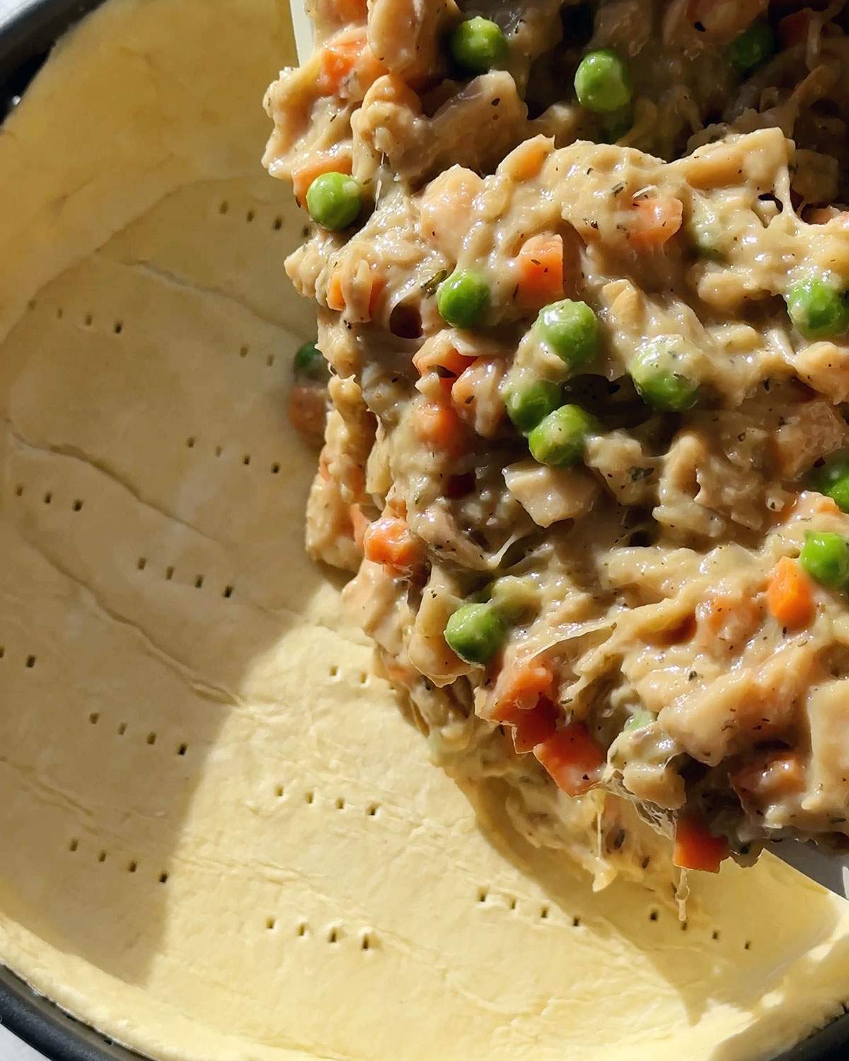 Pouring pie filling into a pie crust.