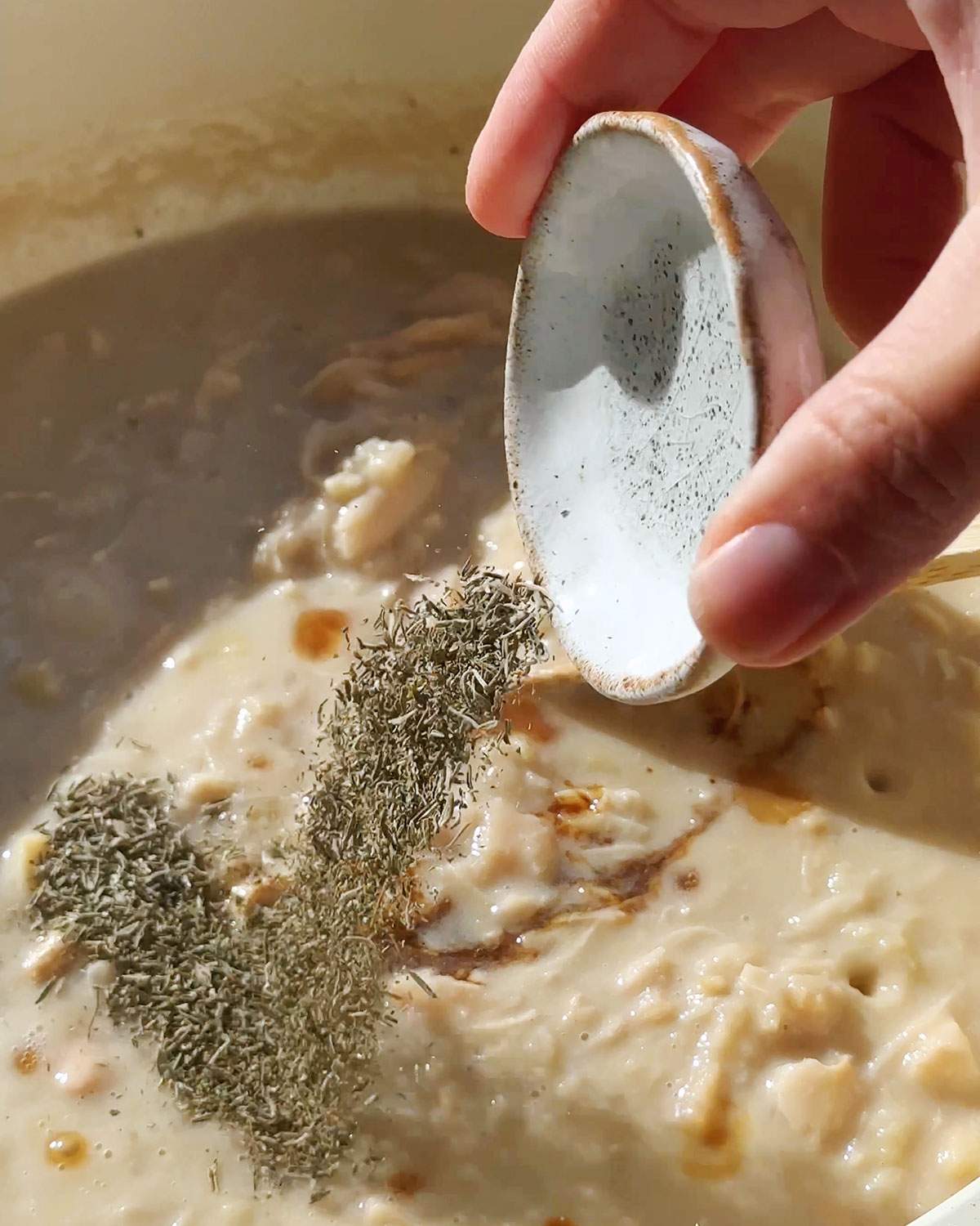 Adding dried thyme into skillet.