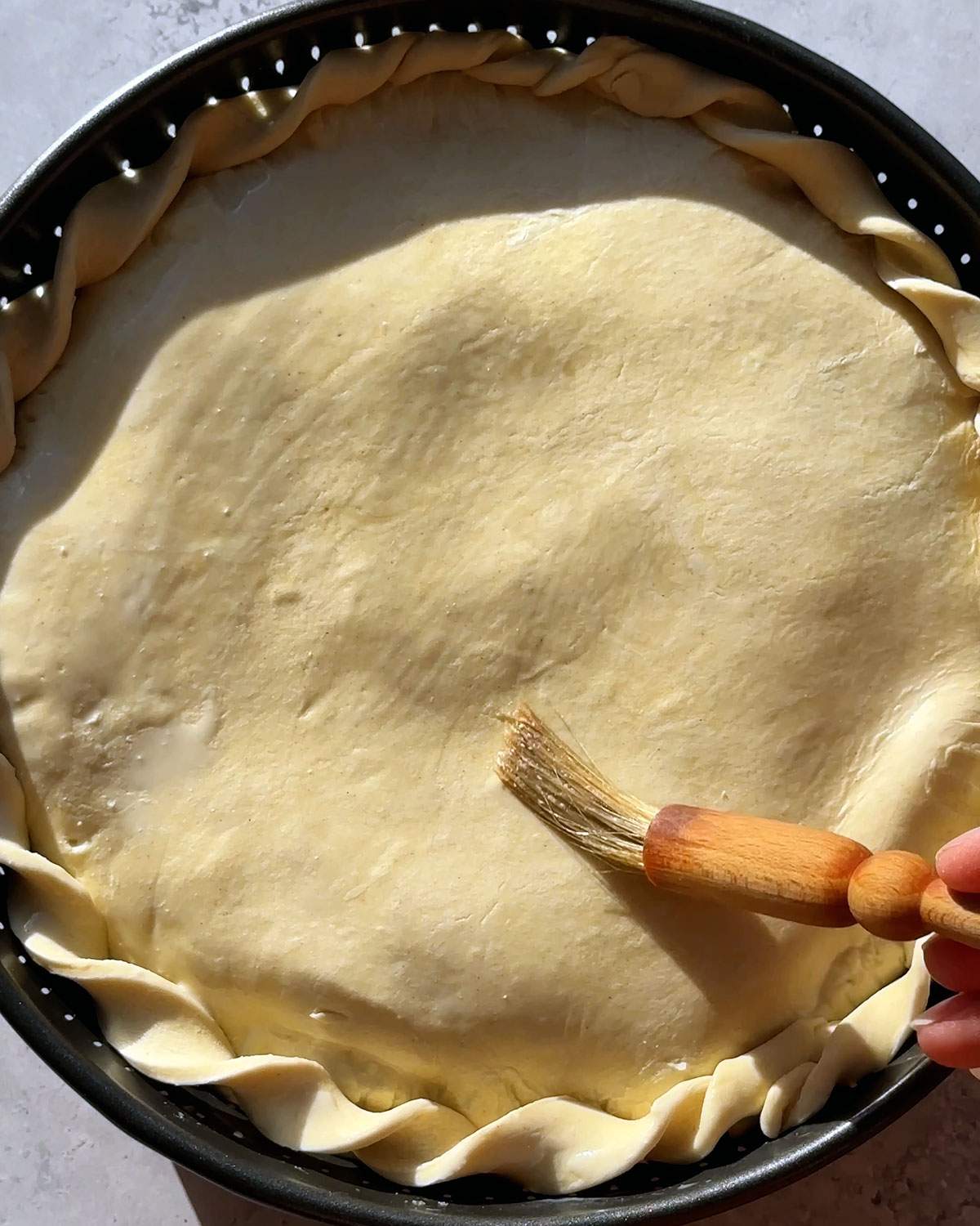 Brushing pastry top crust.