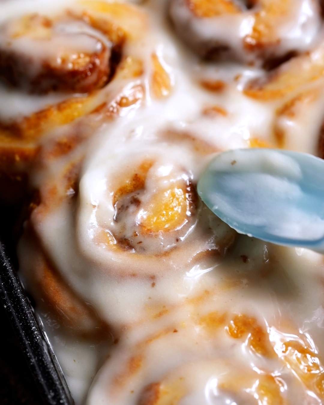 Glazing freshly baked cinnamon rolls.