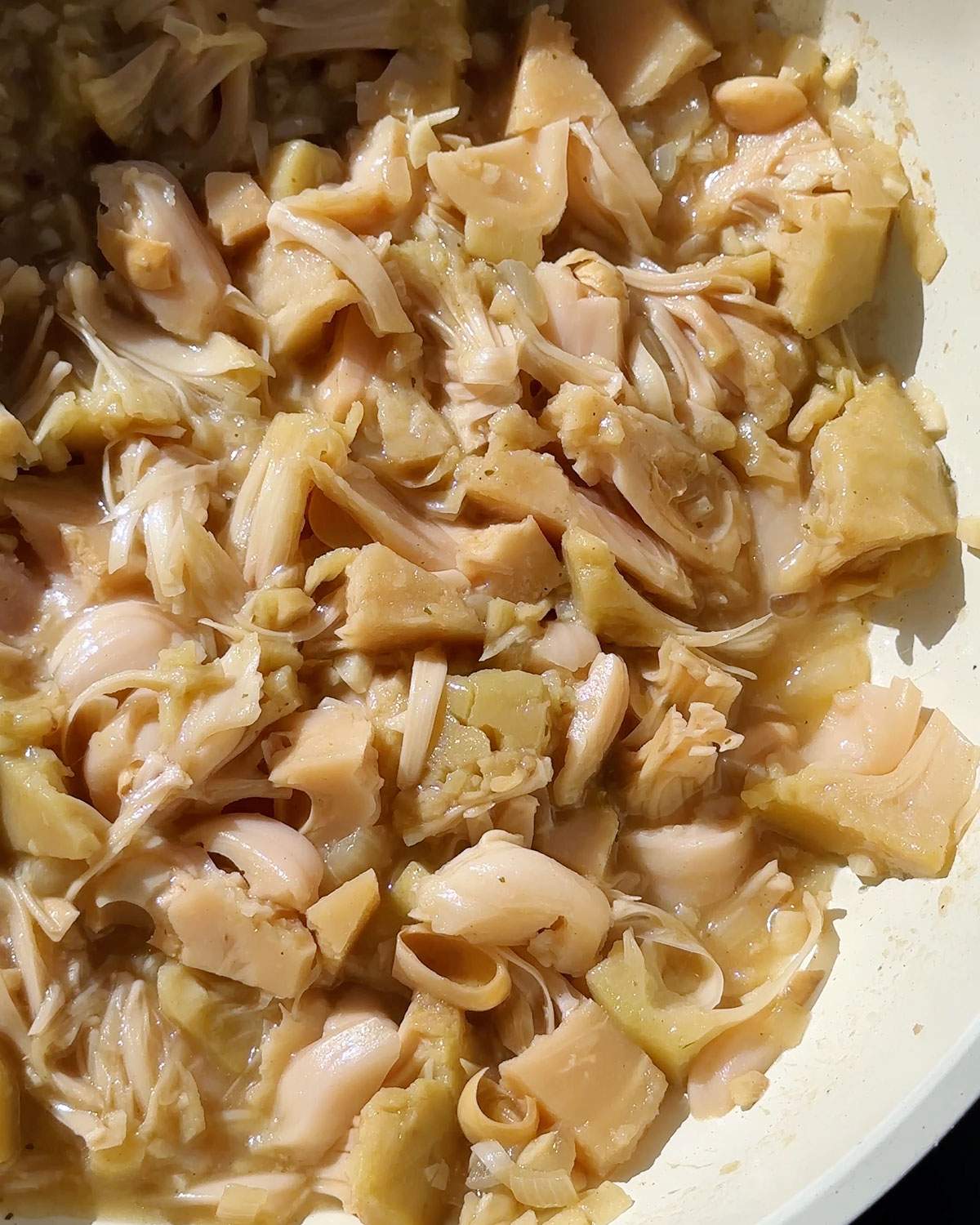 Shredded jackfruit in a skillet.