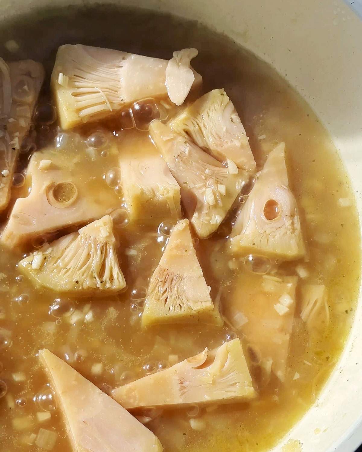Jackfruit pieces simmering in vegetable broth.