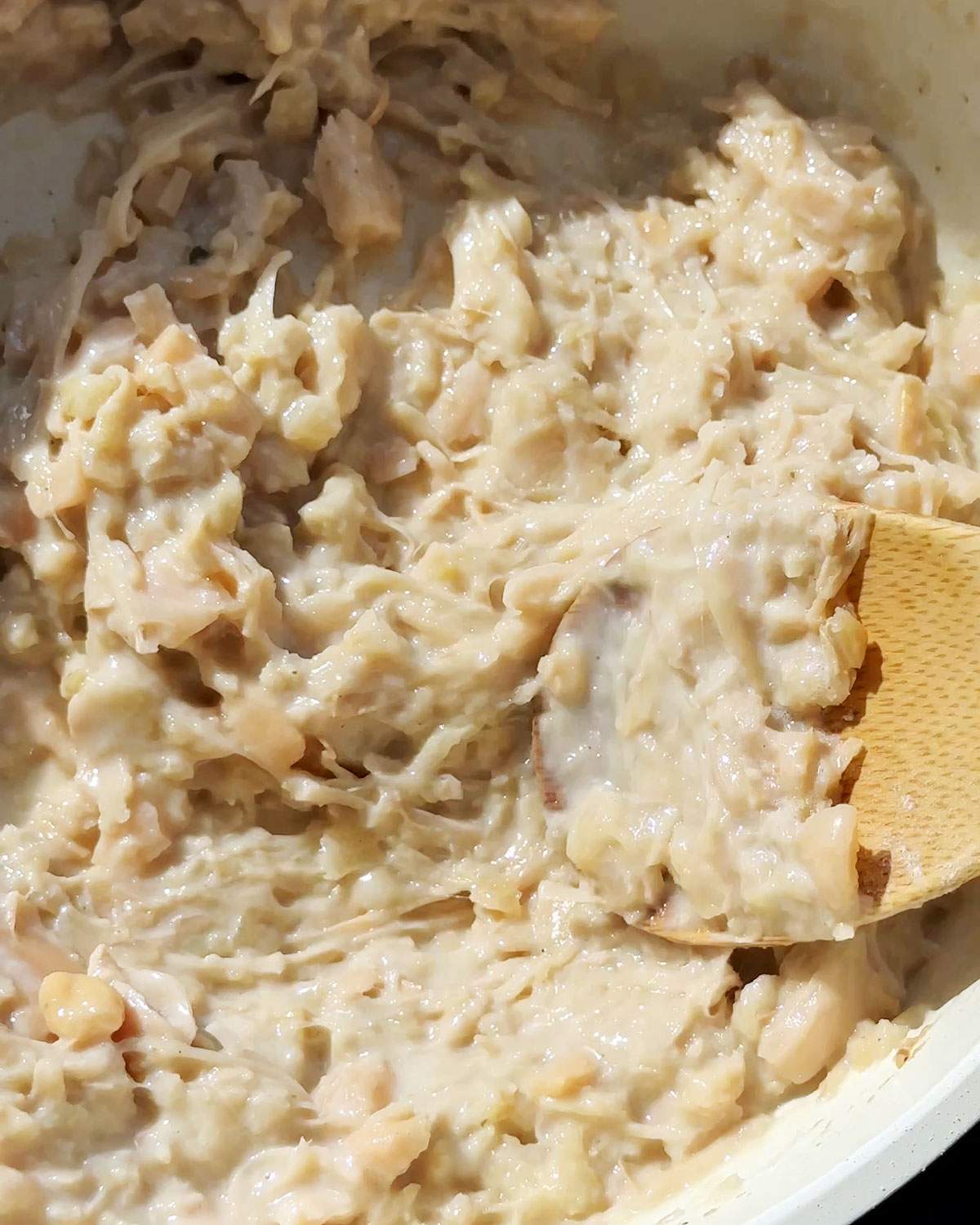 Creamy jackfruit shreds in a skillet.