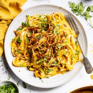 A plate of creamy butternut squash pasta with crispy squash on top.