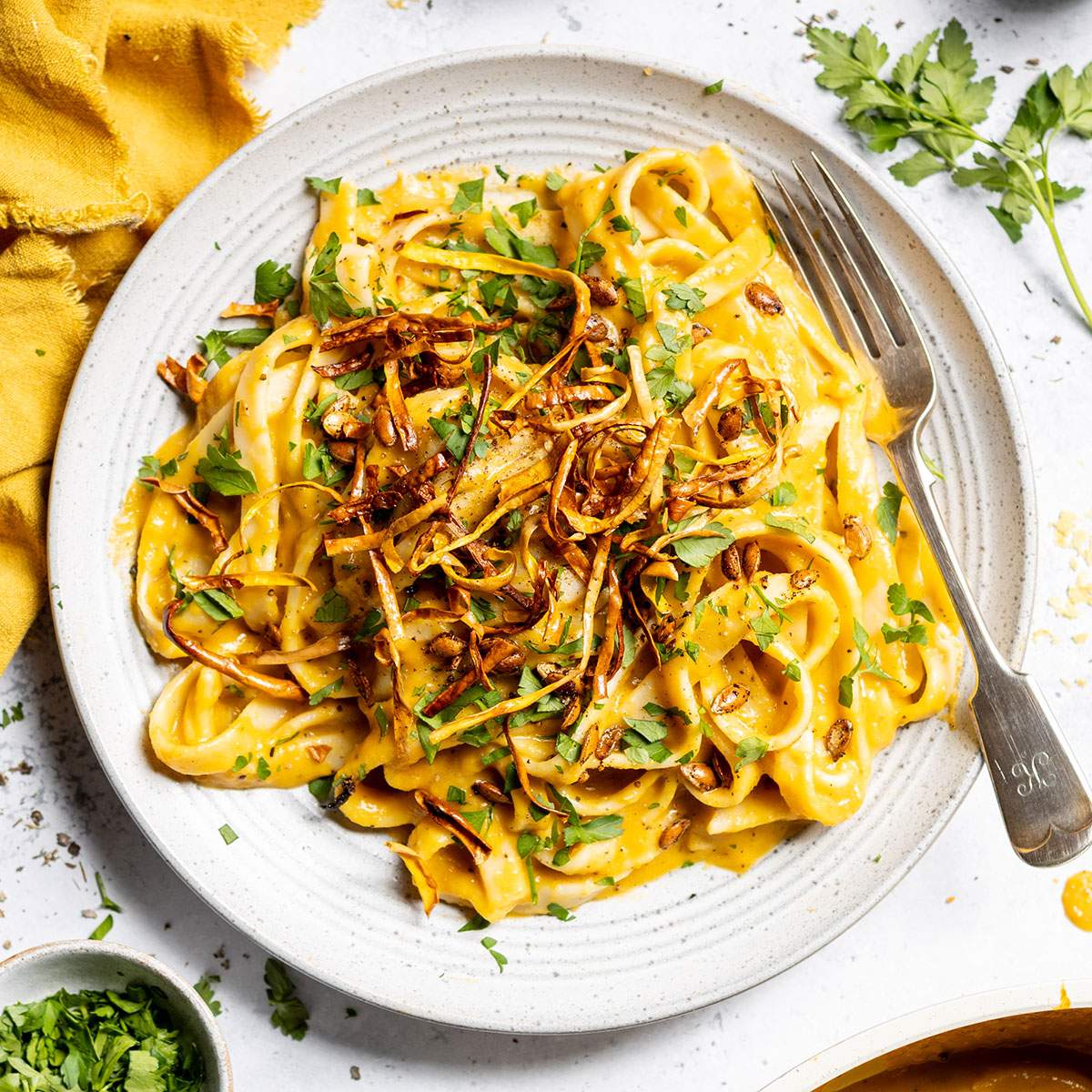 A plate of creamy butternut squash pasta with crispy squash on top.