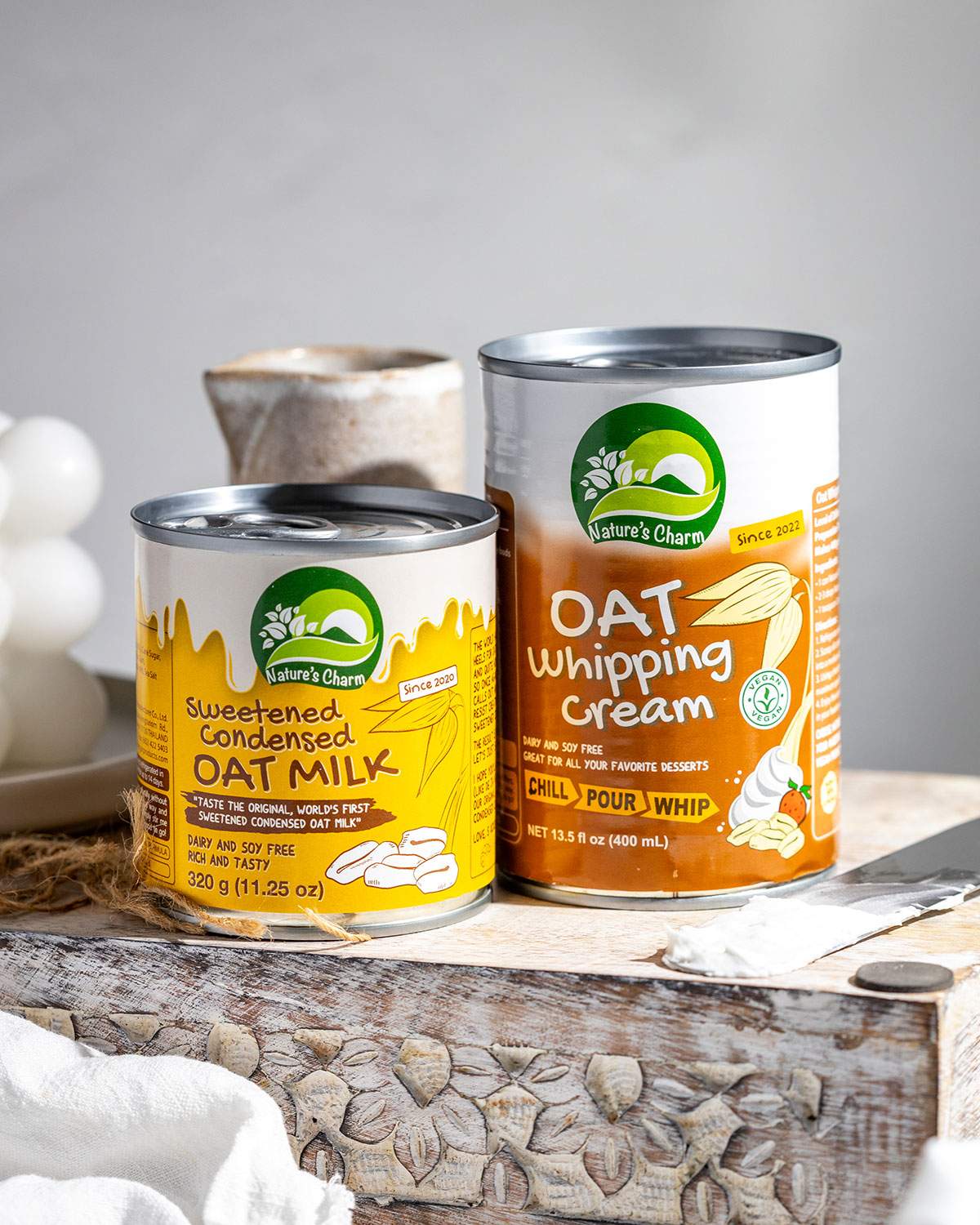 2 cans of Nature's Charm Sweetened Condensed Oat Milk and Oat Whipping Cream.