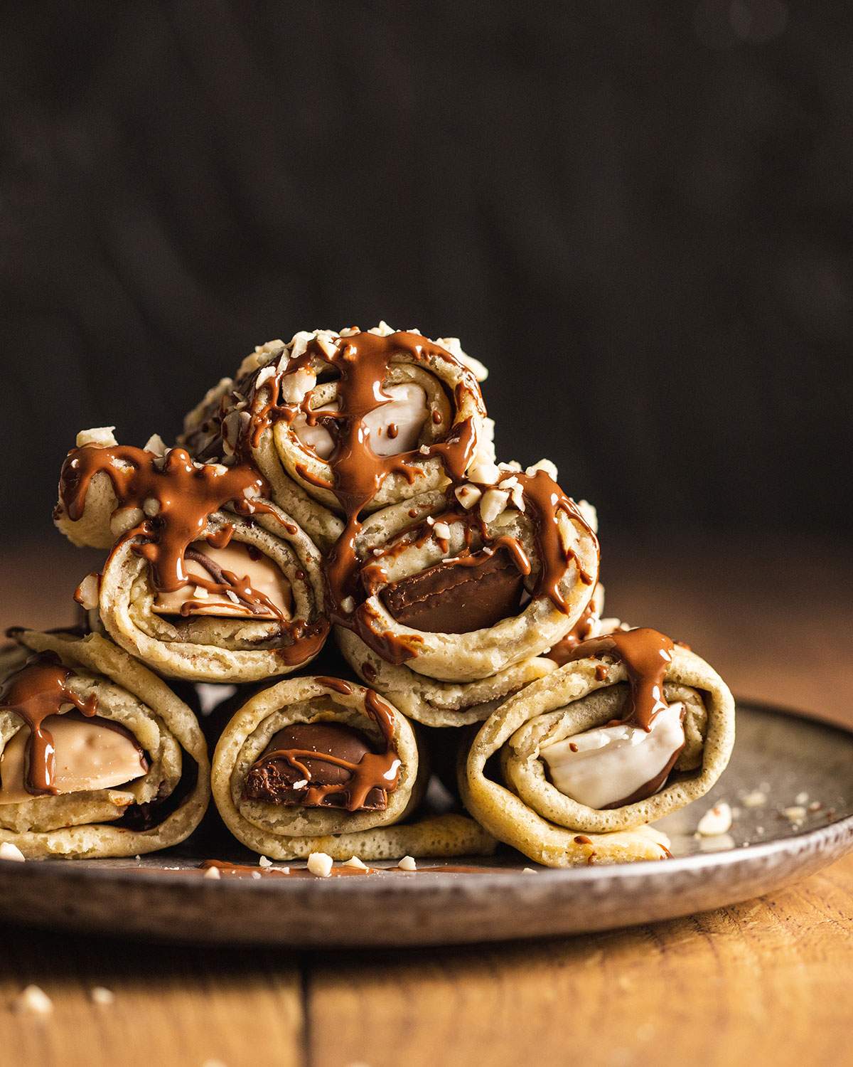 Stacked stuffed crepe rolls on a plate.