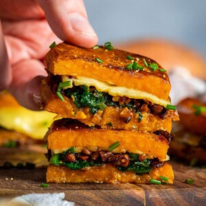 A hand picking up a sweet potato sandwich.