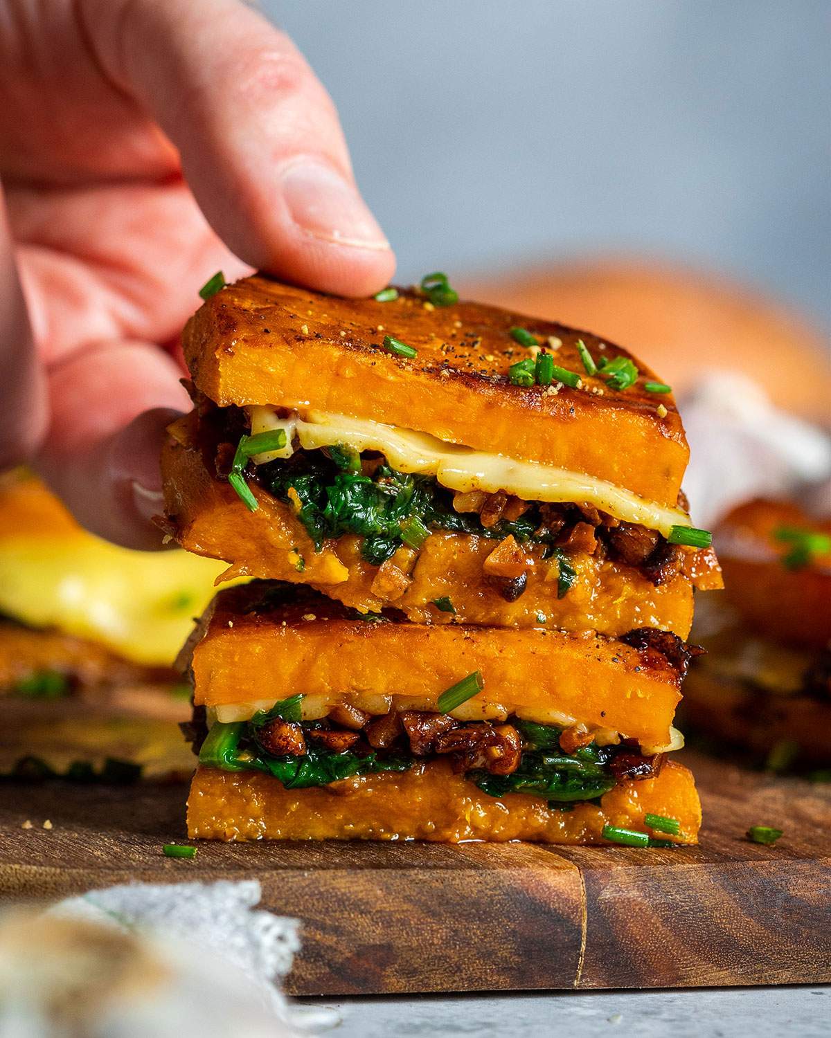 A hand picking up a sweet potato sandwich.