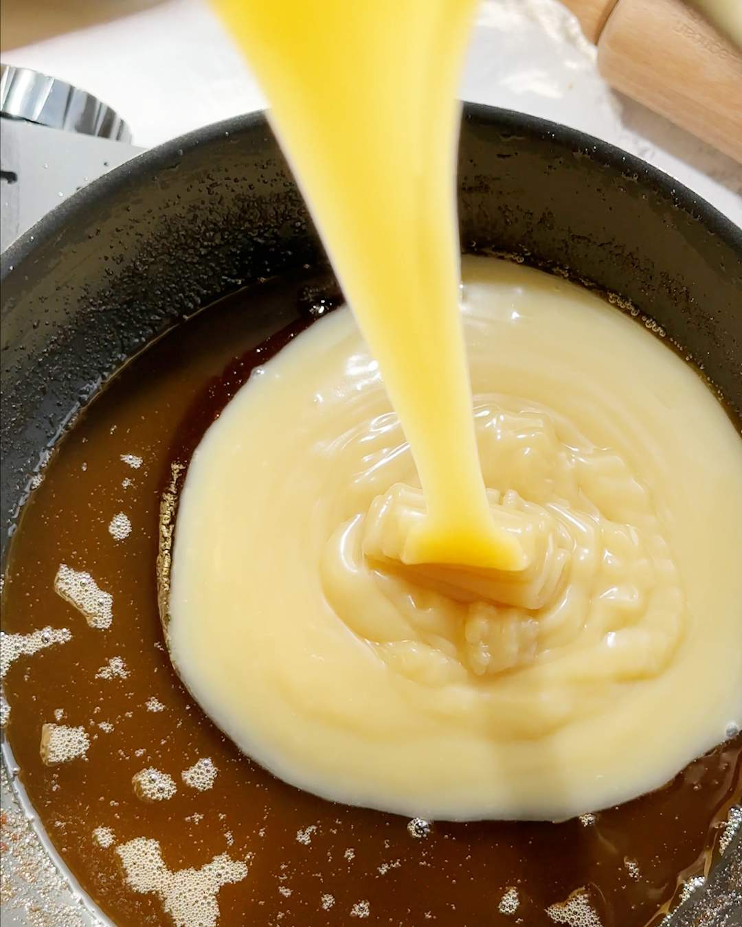 Pouring condensed milk into pan.