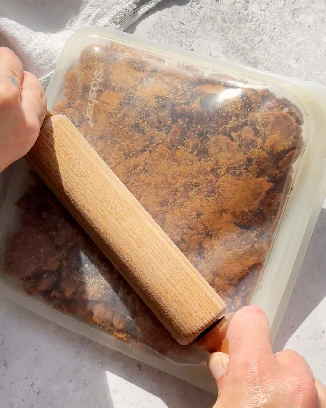 Crushing biscuits in a freezer bag with a rolling pin.