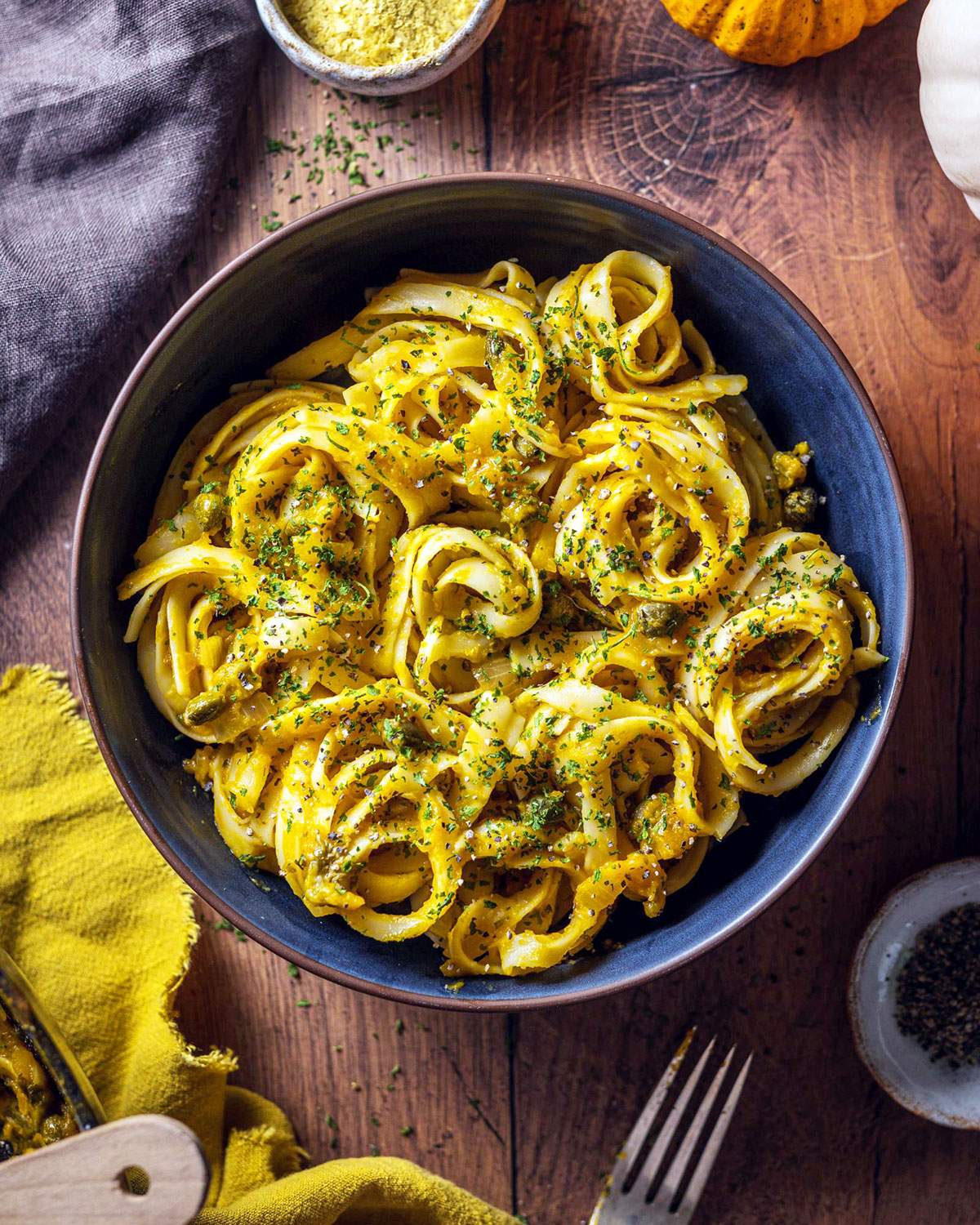 A bowl of creamy pumpkin linguine on the table.