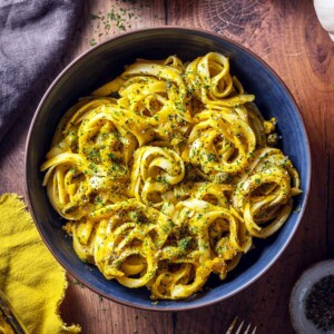 A bowl of creamy pumpkin linguine on the table.