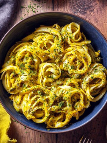 A bowl of creamy pumpkin linguine on the table.