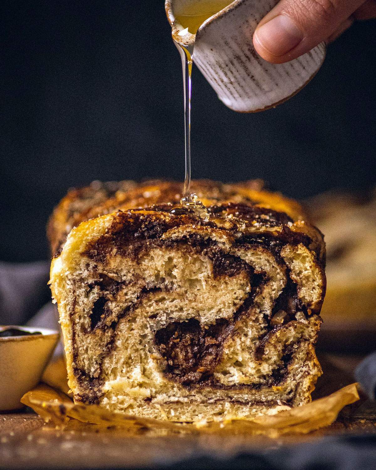 Drizzling syrup onto chocolate babka.