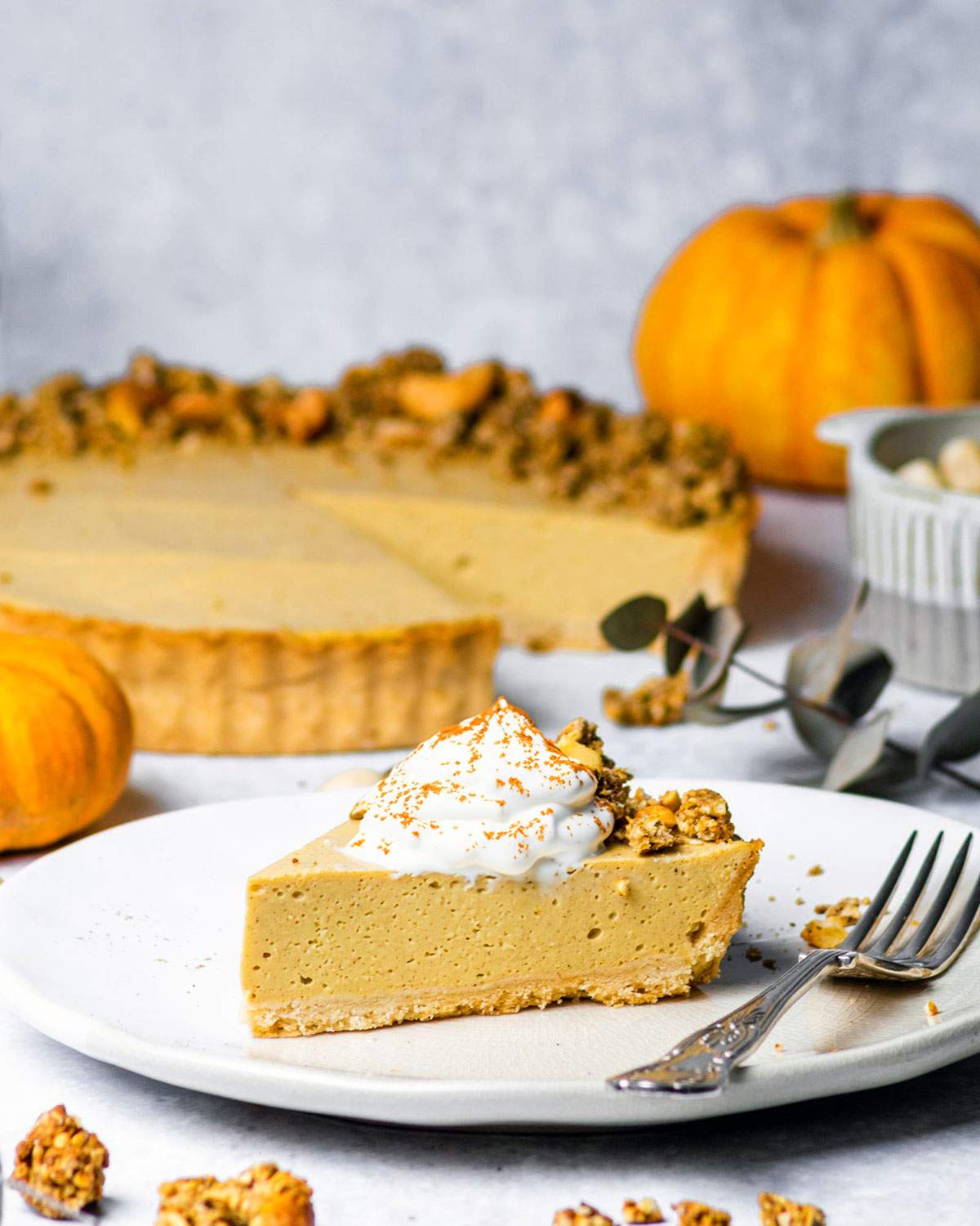 A slice of pumpkin cheesecake with a dollop of whipped cream on top.