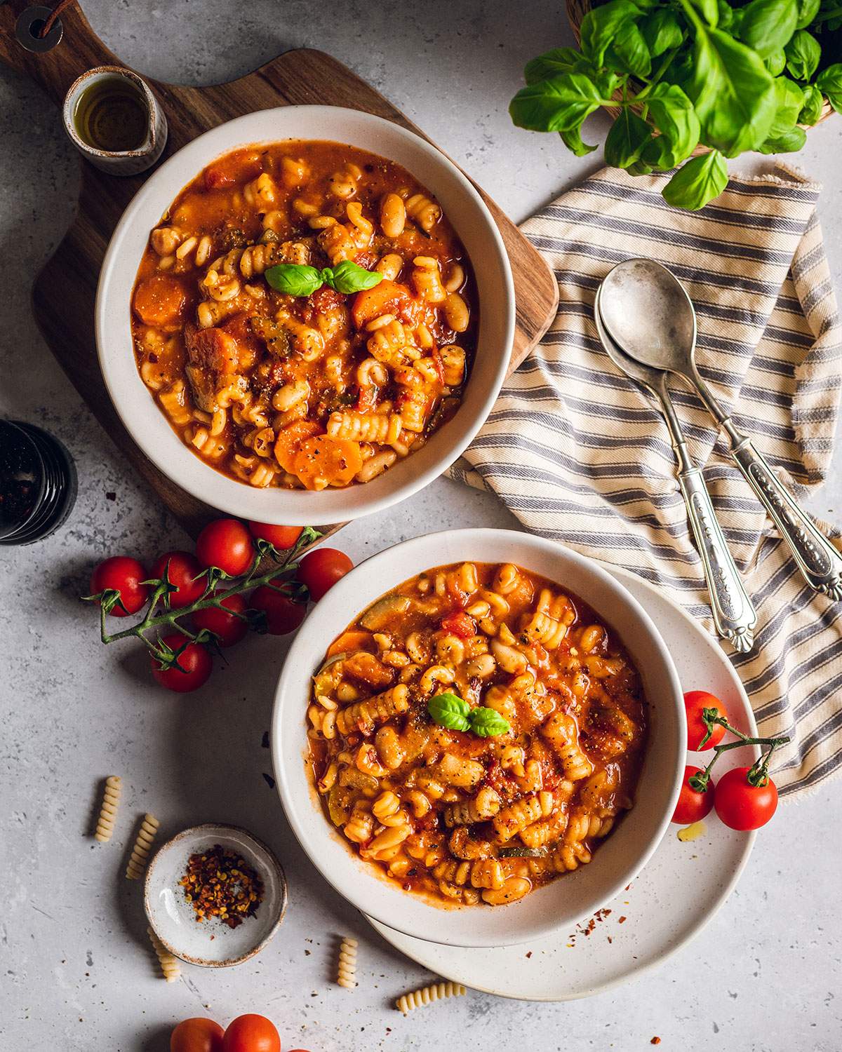 Two bowls of plant based minestrone soup on the dinner table.