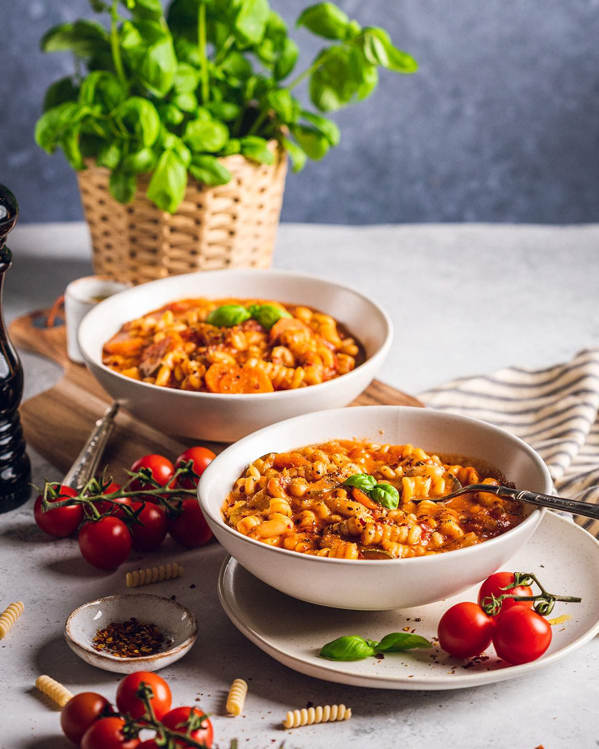 Two bowls of plant based minestrone soup on the dinner table.