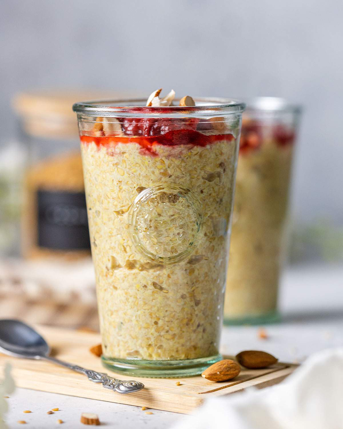 A tall glass with flaxseed pudding and stewed berries on top. 