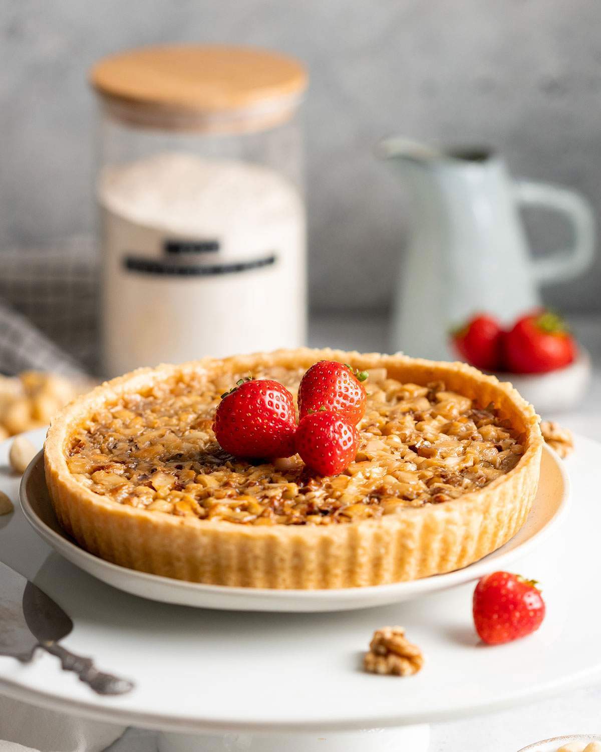A vegan caramel tart decorated with strawberries.