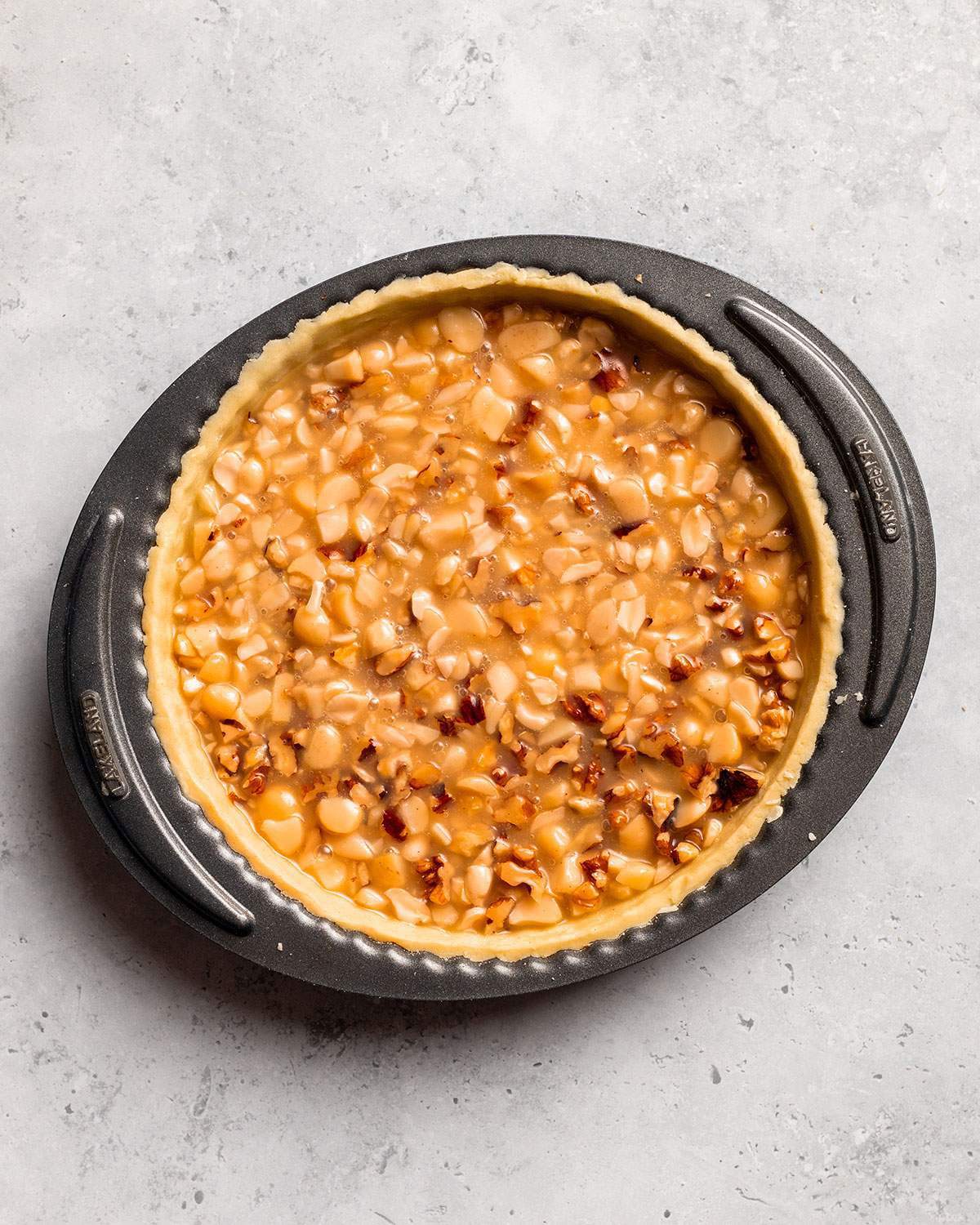 Vegan caramel tart with nuts before baking.