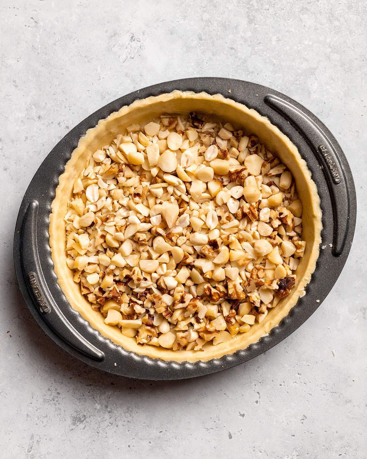 Chopped mixed nuts in a tart base.