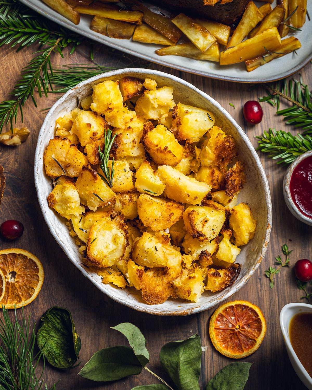 Vegan Roast potatoes in a serving dish on the dinner table.