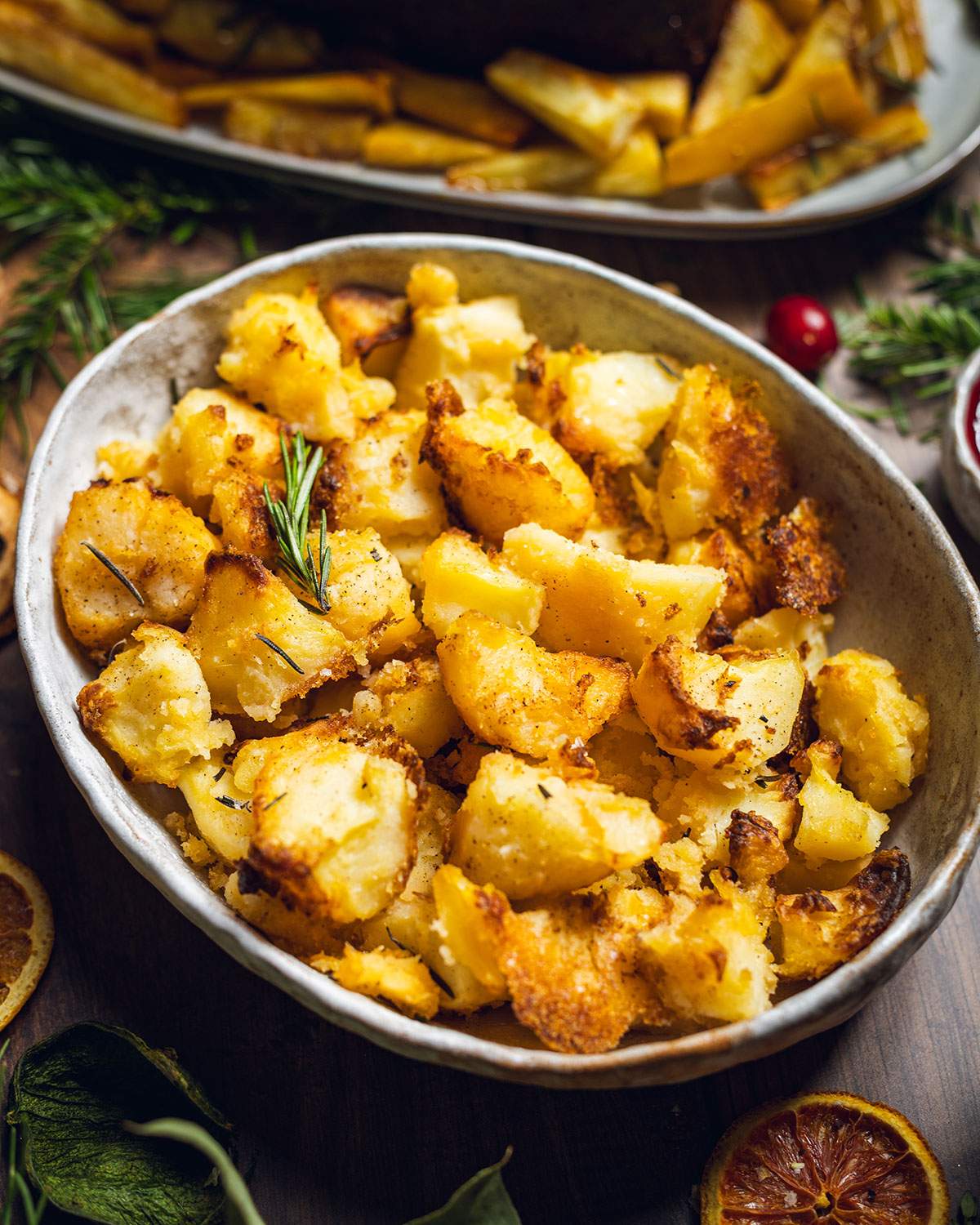 Vegan roast potatoes in an oven dish on the dinner table.