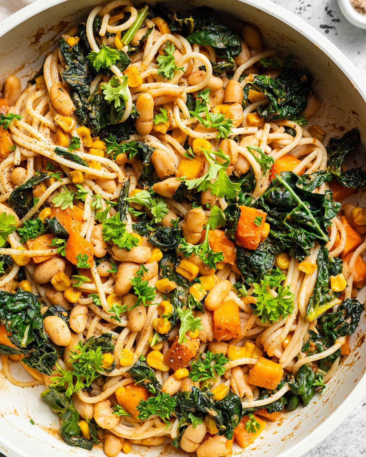Satay Pasta up close in a white skillet.