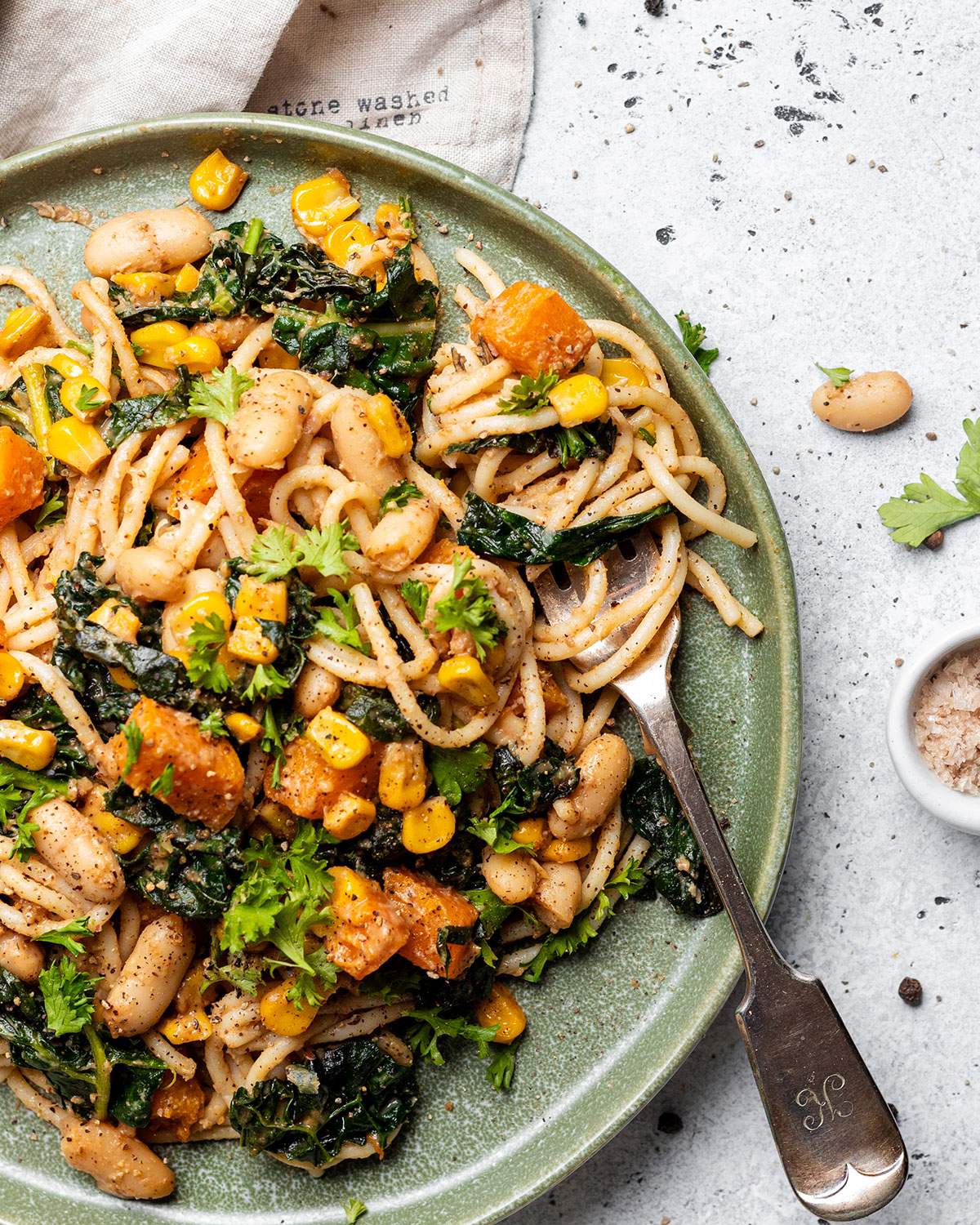 A fork twirling satay pasta on a plate.