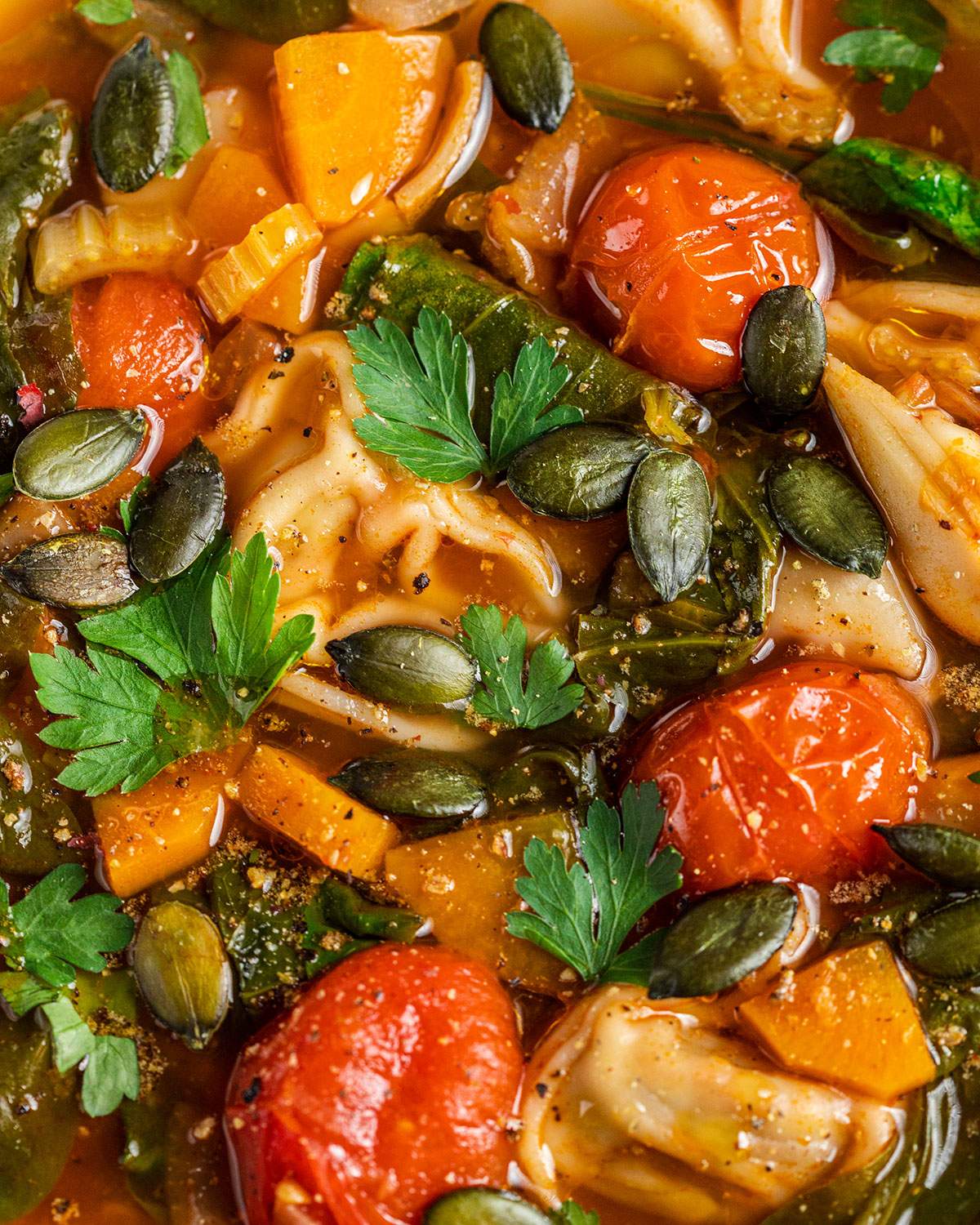 Vegan tortellini in a brothy cosy soup up close.