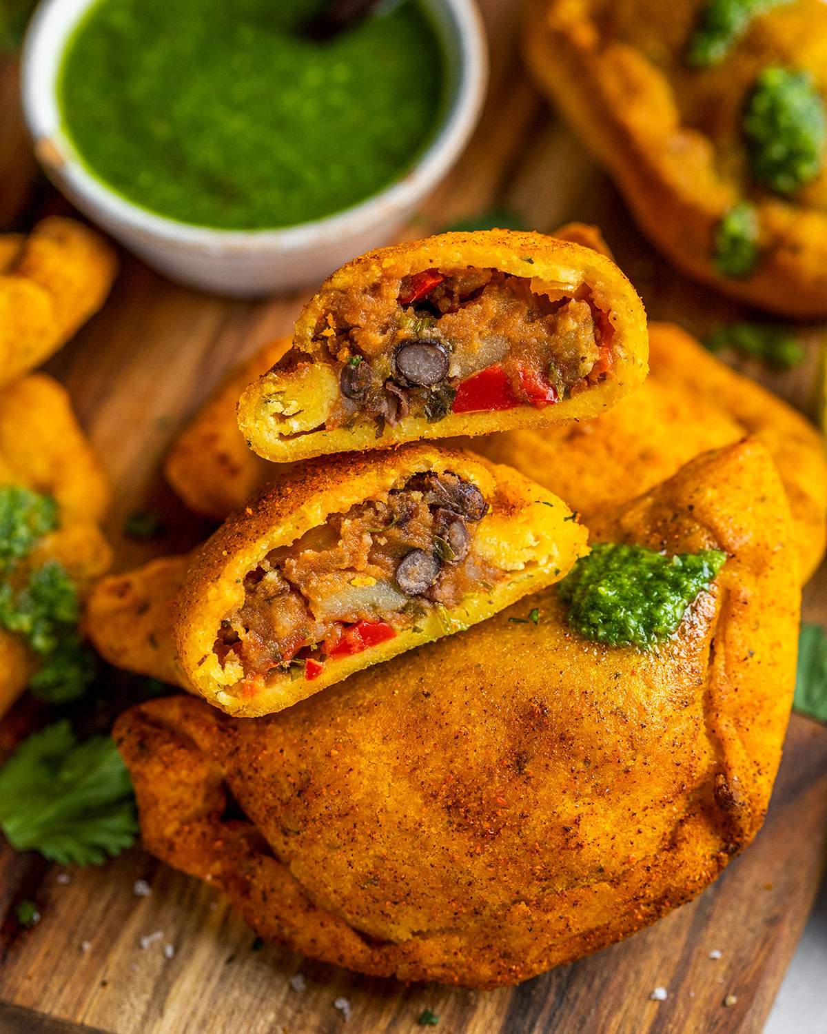 Vegan empanadas on a board cut in half.