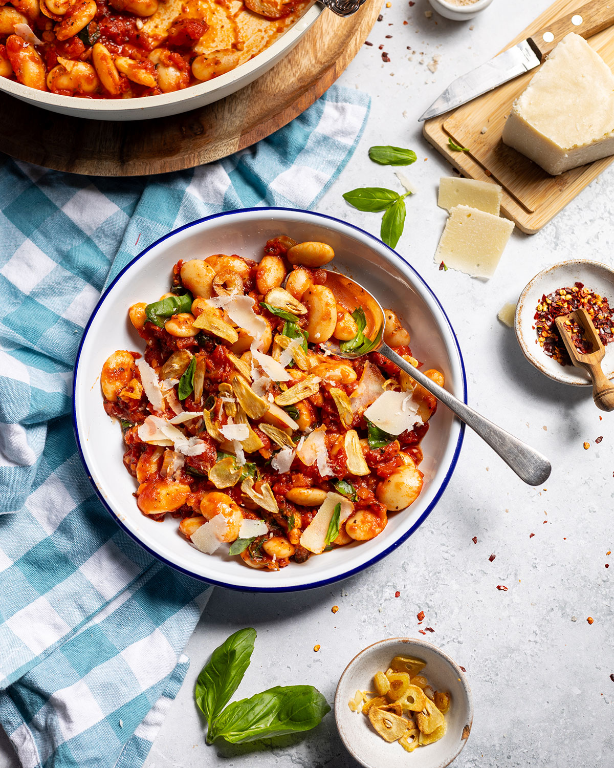 A plate with spicy butter beans on the dinner table.