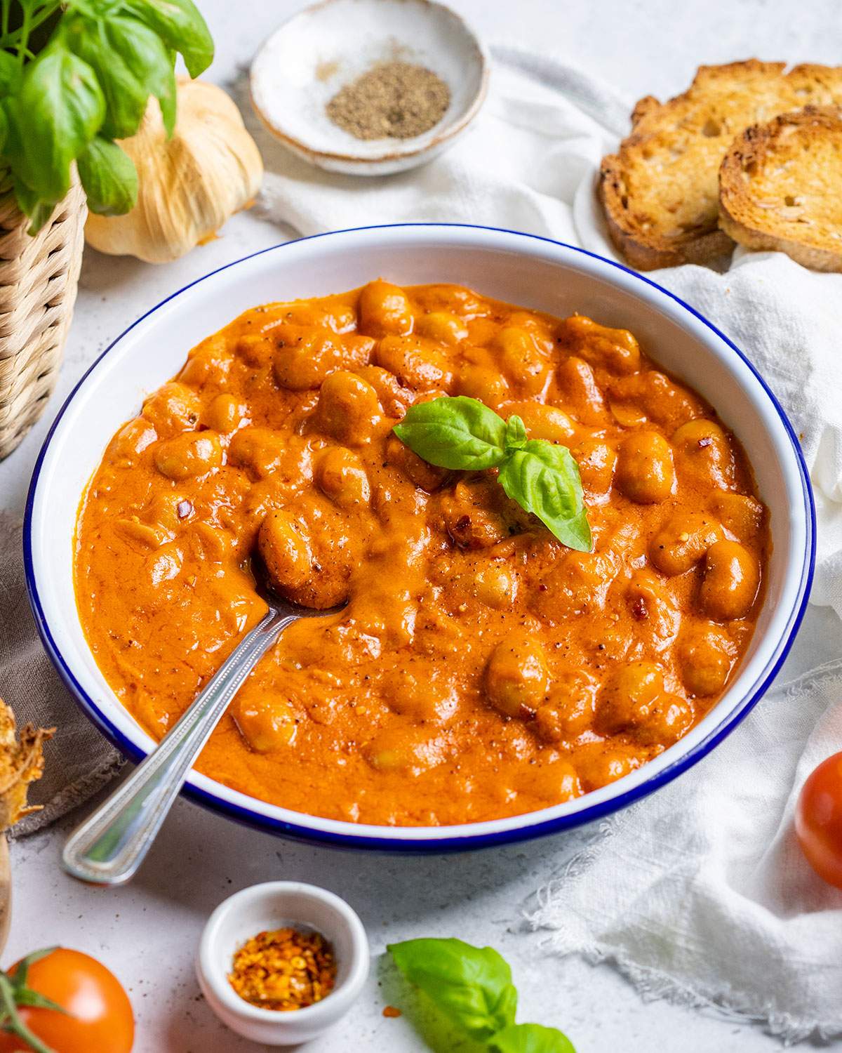 Creamy Beans Alla Vodka on a plate with a spoon on the dinner table.
