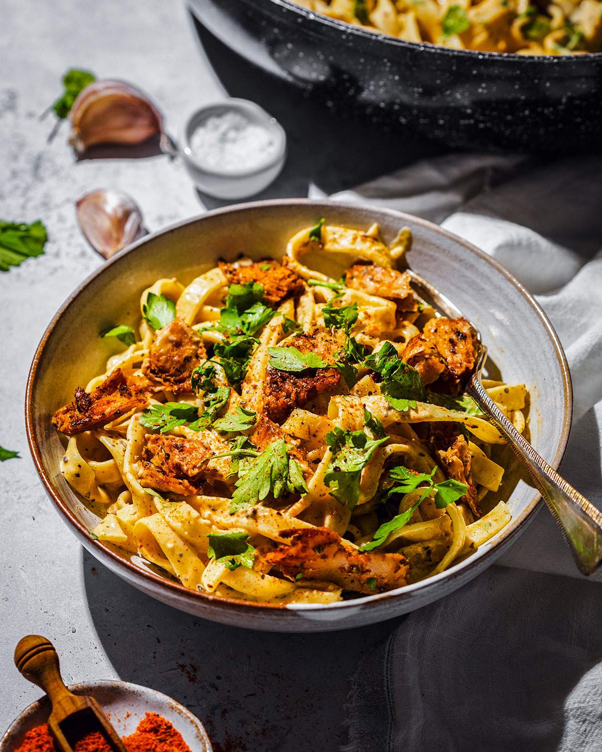 Creamy cajun alfredo with vegan cajun chicken pieces in a pasta bowl.