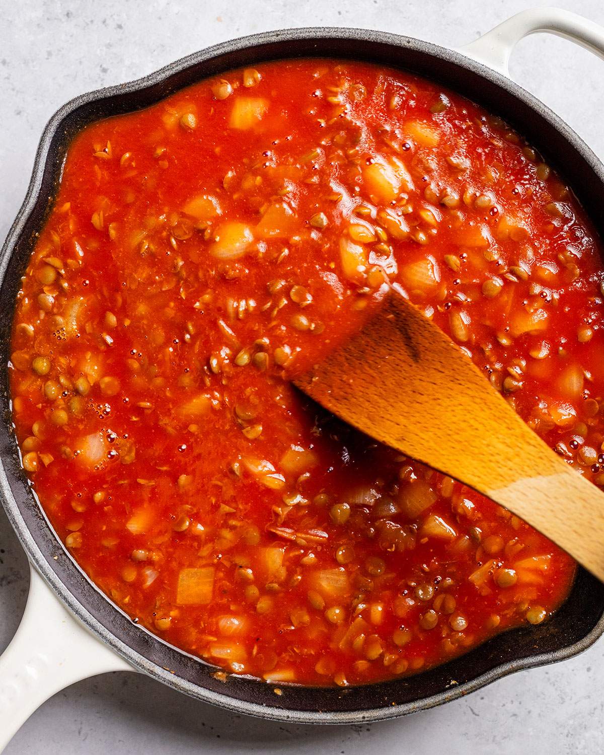 Lentils in tomato sauce in a skillet.