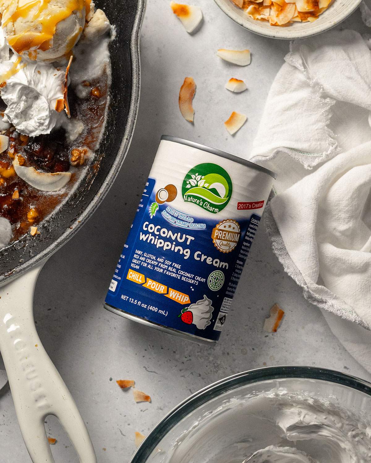 A can of coconut whipping cream next to a skillet.