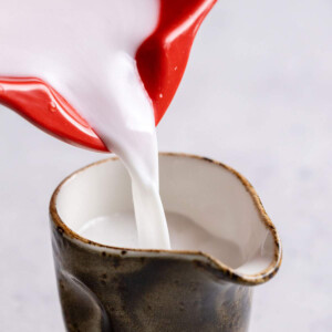 Pouring coconut cream into a jug.