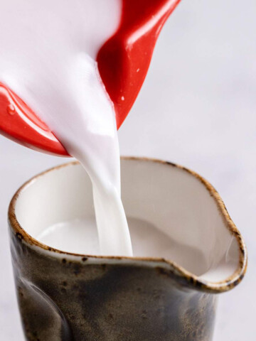 Pouring coconut cream into a jug.