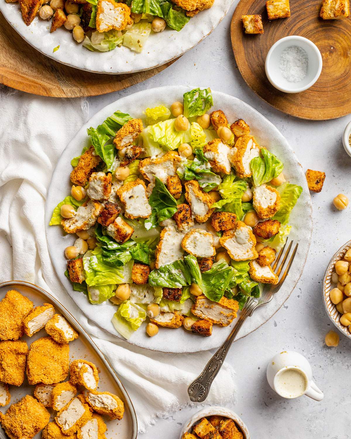 Vegan Caesar salad with crispy tofu pieces and chickpeas on a plate.