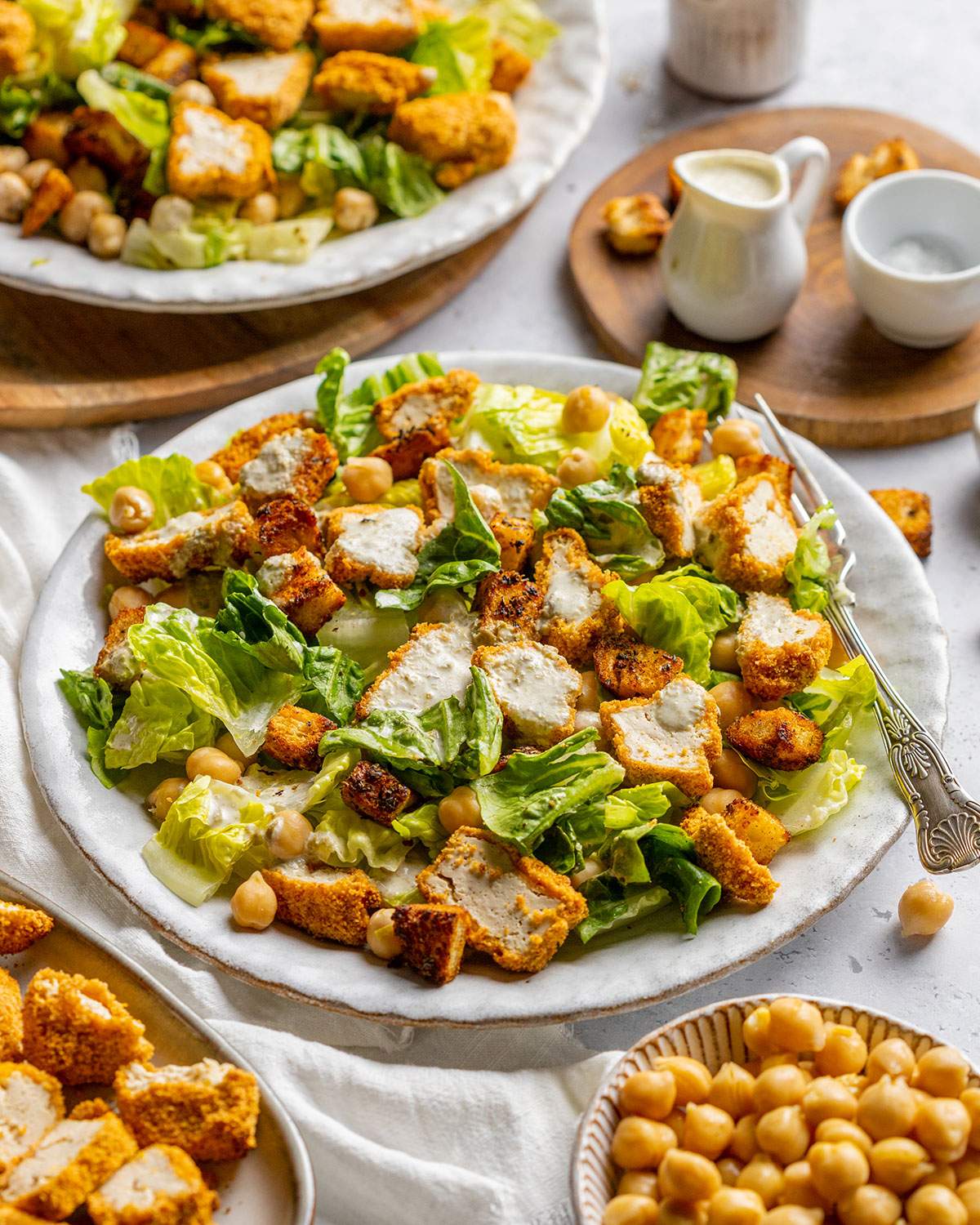 Vegan Caesar salad with crispy tofu pieces and chickpeas on a plate.