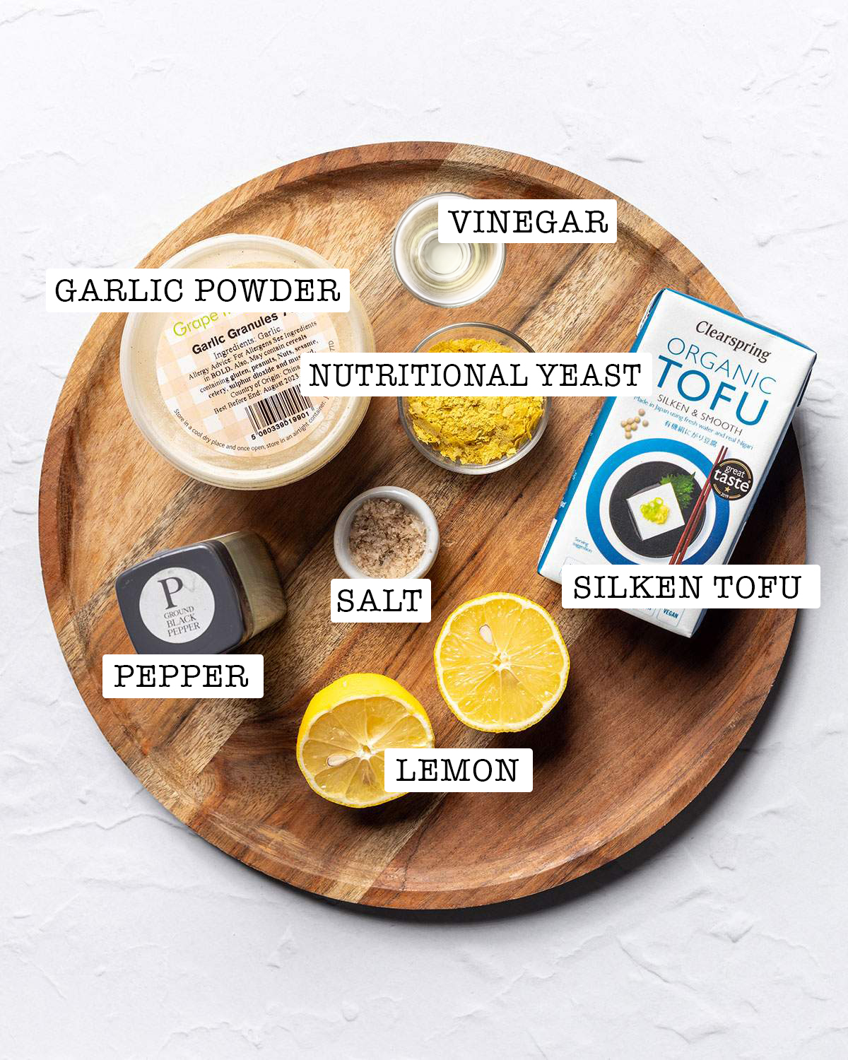 All ingredients for tofu sour cream on a wooden tray with labels.