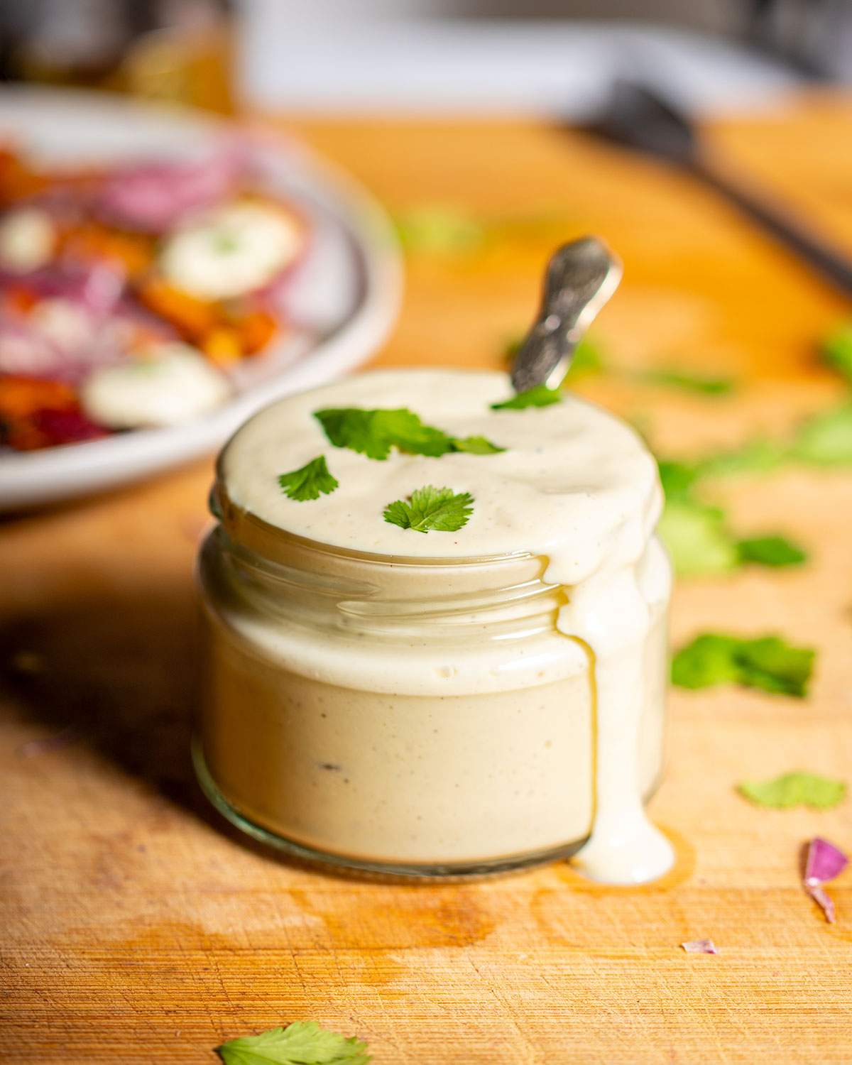 A Full jar of creamy tofu sour cream with a drip on the side.