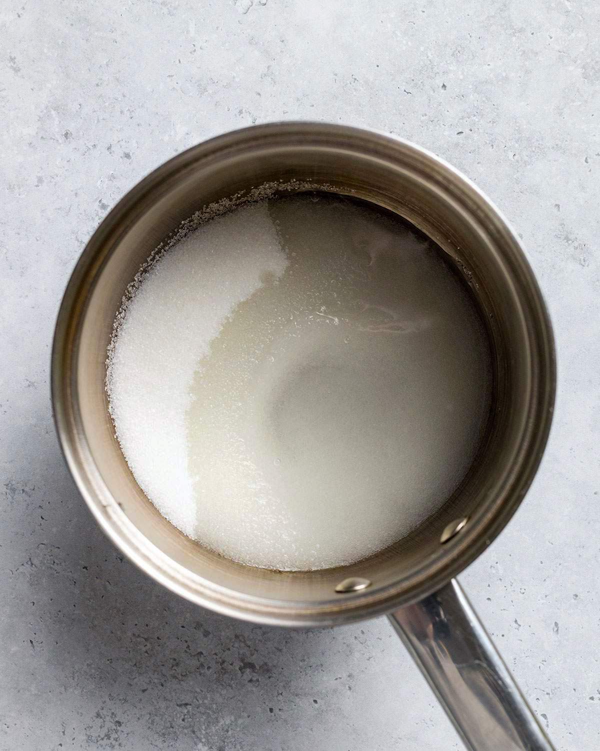 Dissolving sugar in water in a saucepan.