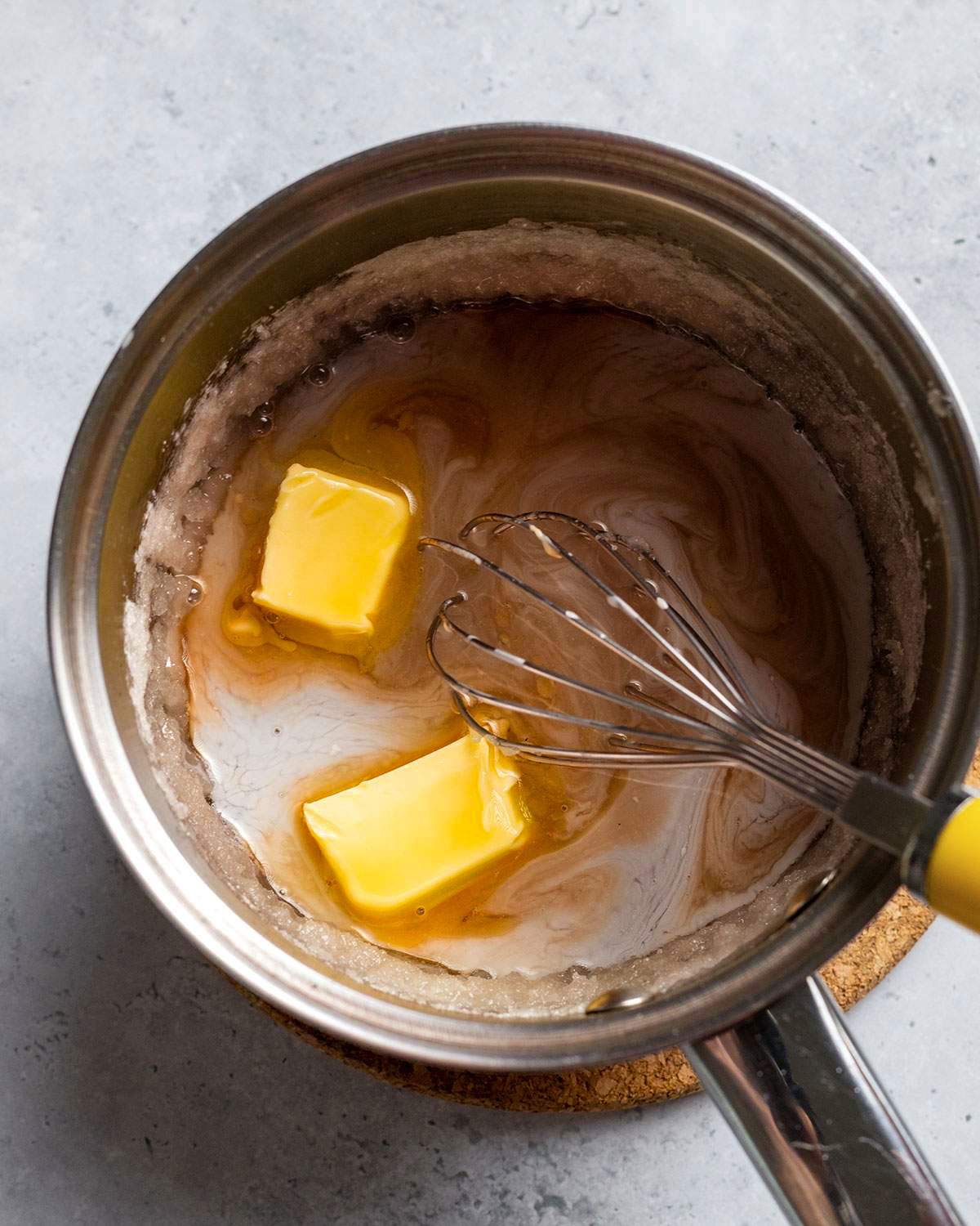 Whisking vegan butter into caramel mix in saucepan.