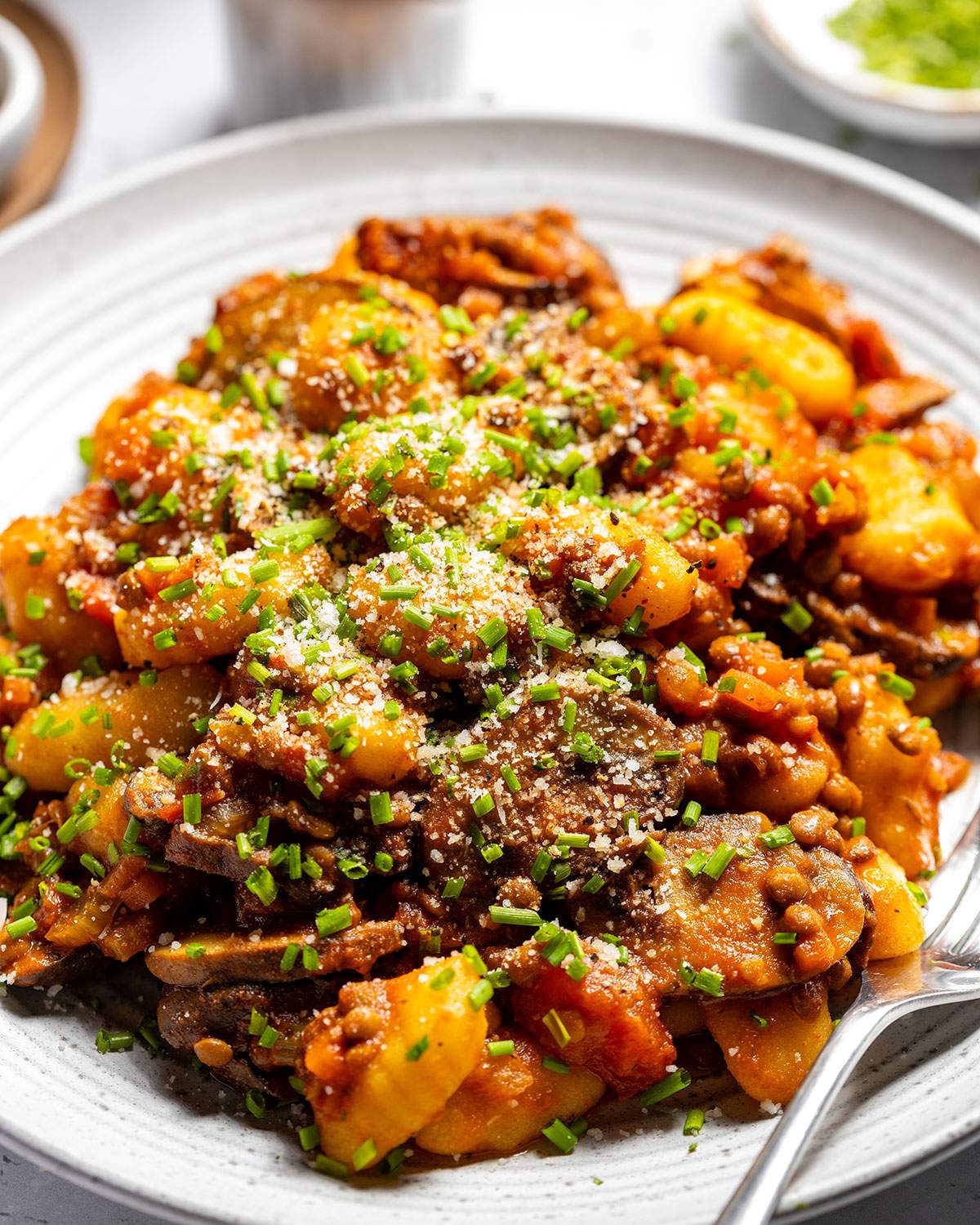 Vegan gnocchi with hearty lentil ragu on a serving plate.