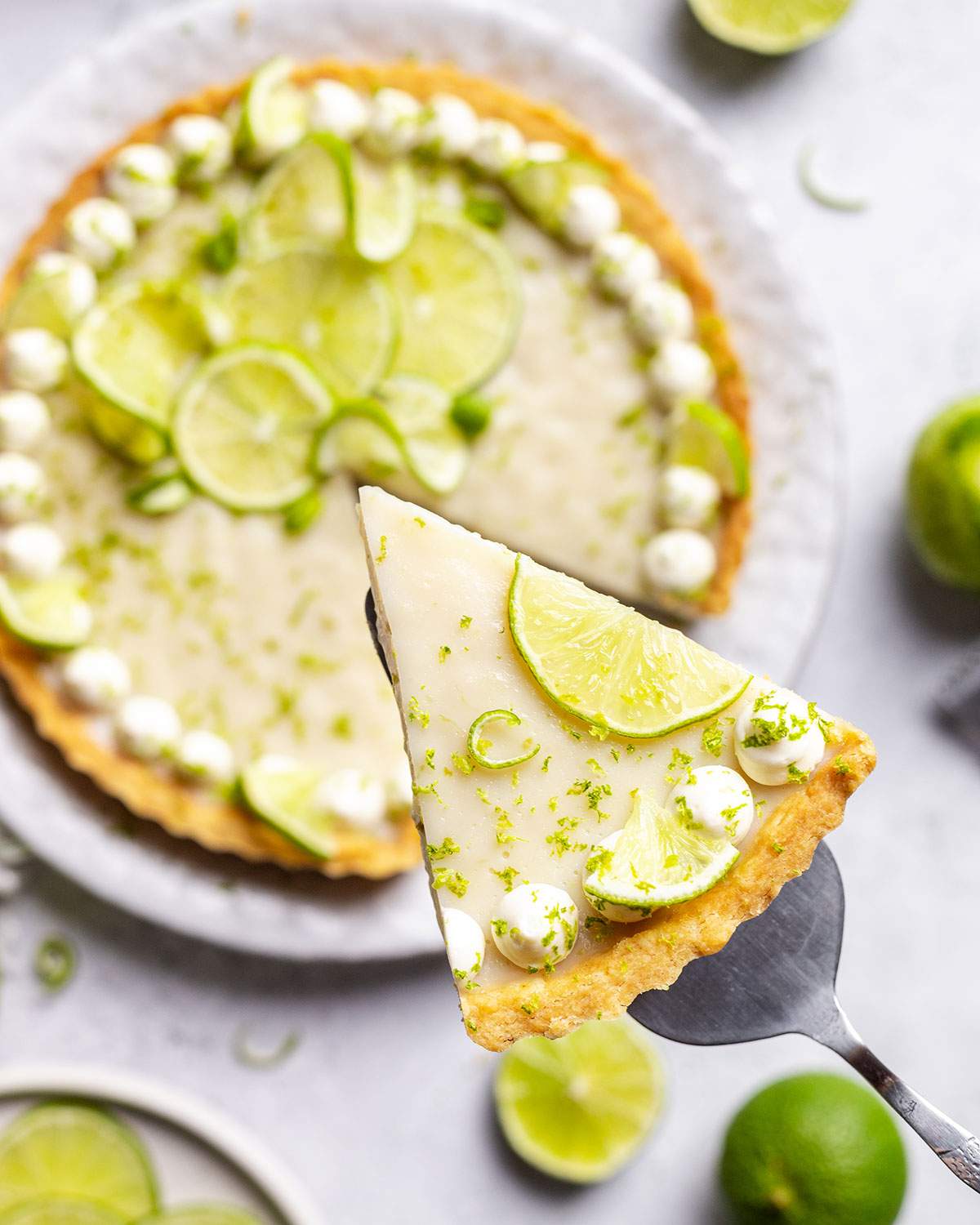 A slice of vegan key lime pie above the rest of the lime pie.
