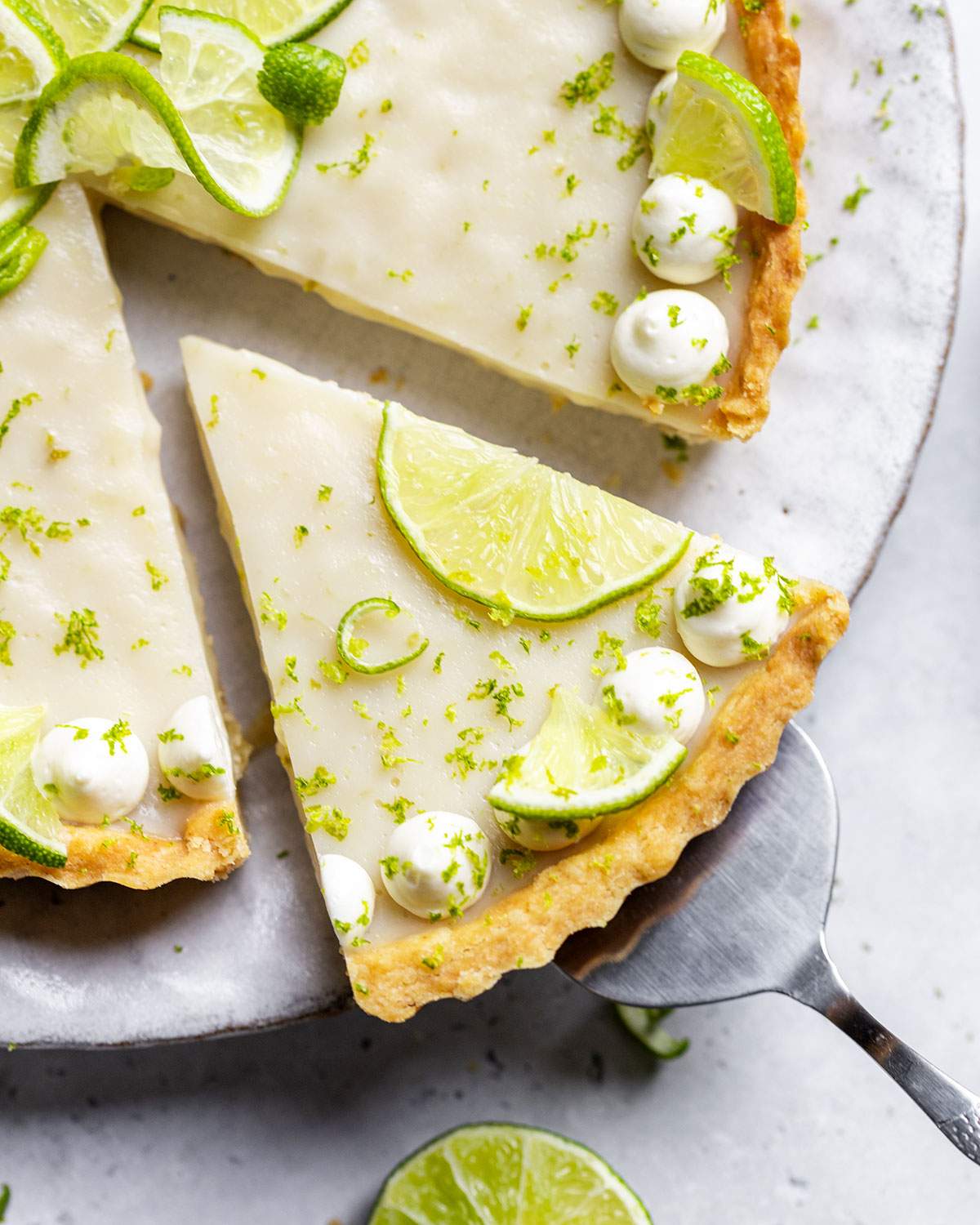 A slice of vegan key lime pie cut out of the whole pie.