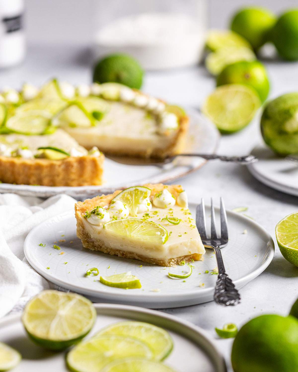 A slice of vegan key lime pie on a dessert plate on the table.